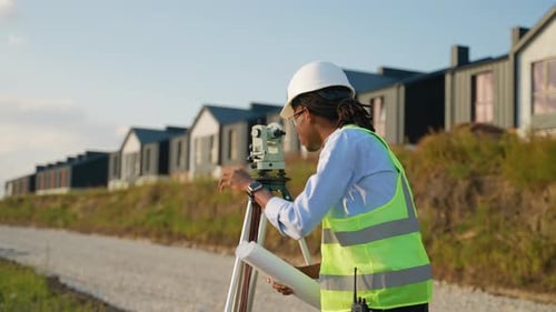 Construction Worker Reads Plans, Surveying New Neighborhood