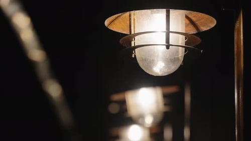 The old building is illuminated by lamps at night, it is snowing