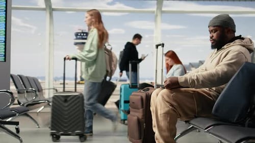 Homme professionnel indépendant tapant sur un ordinateur portable dans la zone d'attente de l'aéroport