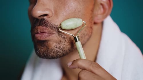 Close up of man massaging face with beauty tool