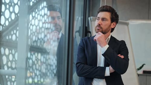 Man Thinking Looking Out Window in Modern Office