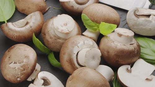Champignons royaux mûrs avec tranches de champignons et feuilles de basilic.