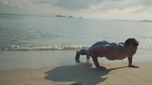 Asian man workout push up exercise in outside beach outdoor fitness