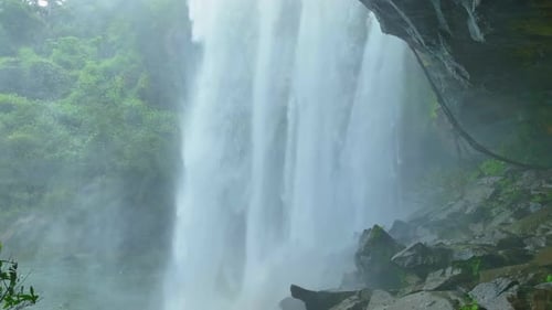 View of a waterfall from inside a cave in Tropical paradise