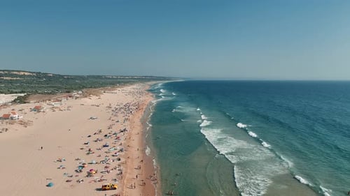 A Beautiful Aerial View of a Tranquil Beach Filled with Sunbathers Enjoying the Gentle Waves