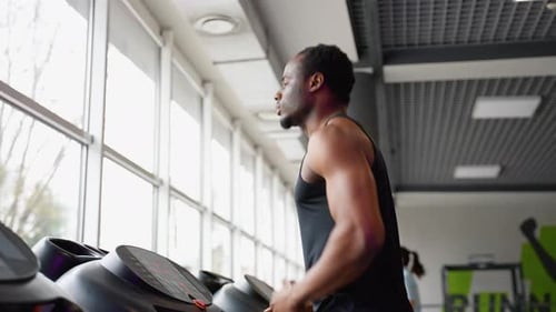 Handsome Man Running on the Treadmill in Gym