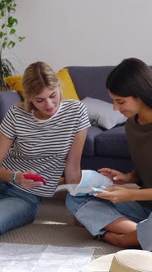 Women Friends Plan Travel Indoors with Maps