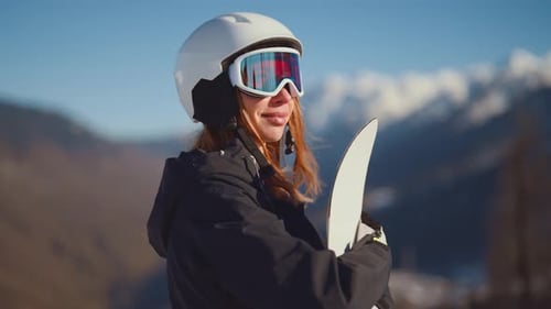 Woman Snowboarder on Mountain in Sunny Winter