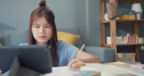Young Woman Studying at Home with Tablet