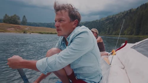 Couple Rides Boat Down River Using Paddle