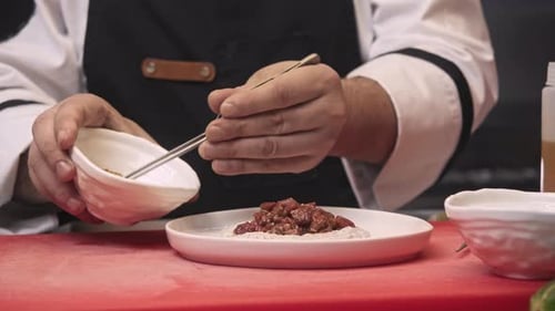 Chef Garnishing Food with Tweezers in Restaurant Kitchen