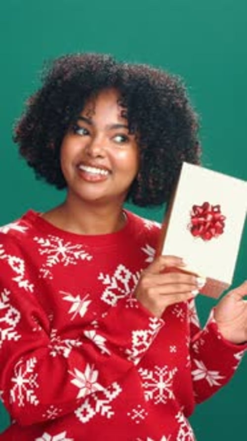 Christmas, shake gift and face of woman in studio for holiday, tradition and festive season