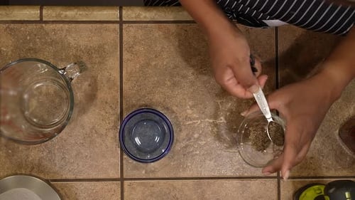 Measuring out fresh ground black pepper for a homemade vegetarian, vegan recipe - overhead view WILD