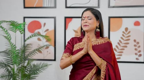 Woman in Sari with Prayer Hands Indoors