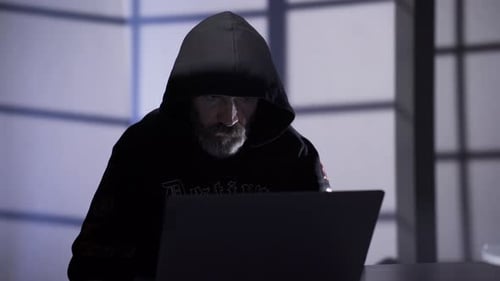 Hacker man starts typing on laptop keyboard and cracking password.