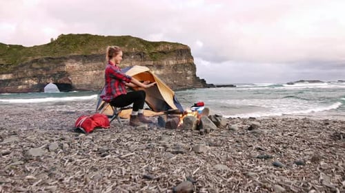 Independent Young Traveler Woman Hiker Keeping Warm and Relaxing by Campfire After