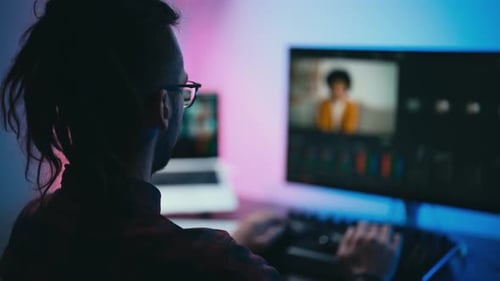 Young Adult Editing Video at Computer Workstation