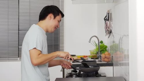 Young Adult Cooking in Modern Kitchen