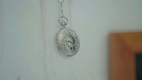 Vintage Silver Pocket Watch with Chain on Wall