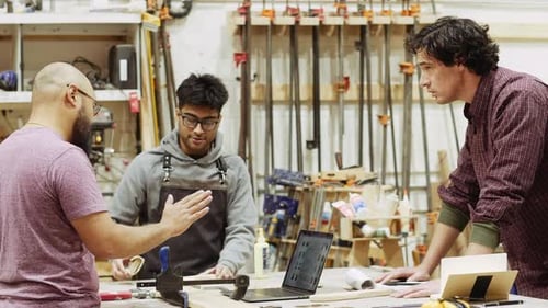 Male Carpenters Meeting Brushing Wood At Carpentry Workshop