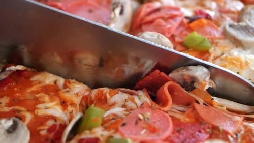 Close Up of Pizza Being Cut