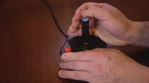 Hands Using a Vintage Black Joystick Controller