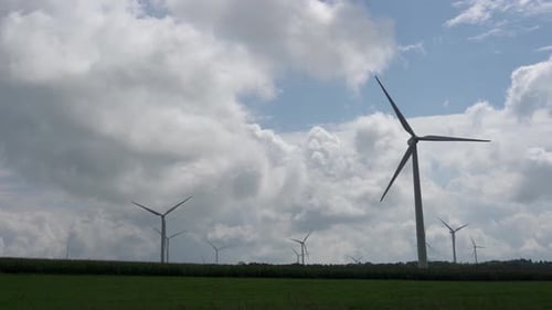 Ein Windpark auf einem Feld auf einem Hügel.