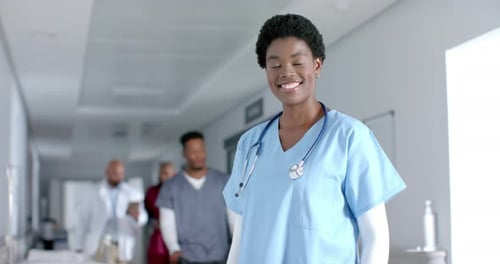 Smiling Nurse Poses in Hospital Hallway
