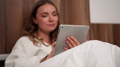 Close Up in Modern Clinic in a Bright VIP Room a Young Girl in a White Coat Lies on a Bed Before an