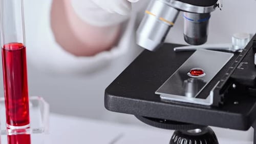 Microscope Analyzing Blood Sample in Lab
