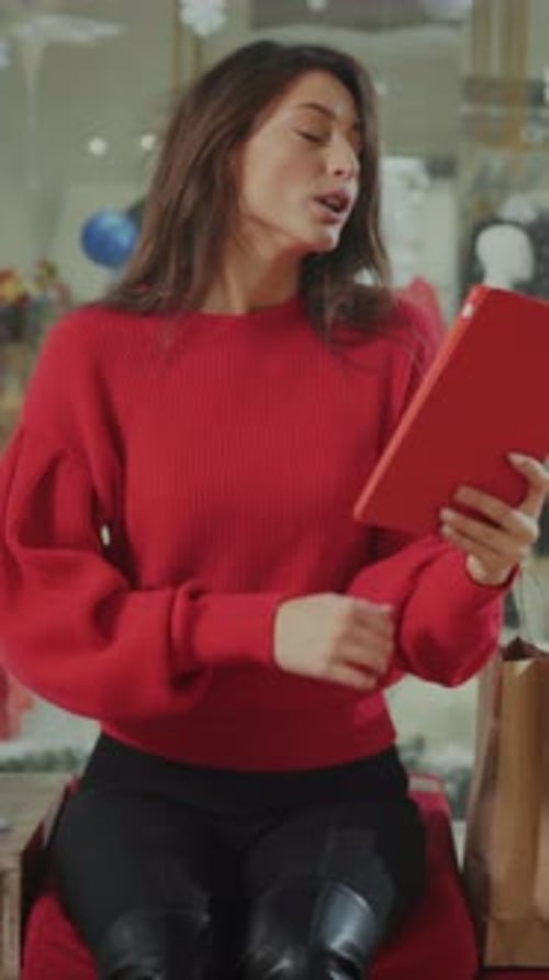 Female Browsing Gifts Comfortably Seated Woman Dressed Warmly Examines Shopping Options Near Festive