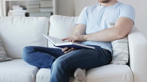 Leisure, Education, Literature and People Concept - Close Up of Man Sitting