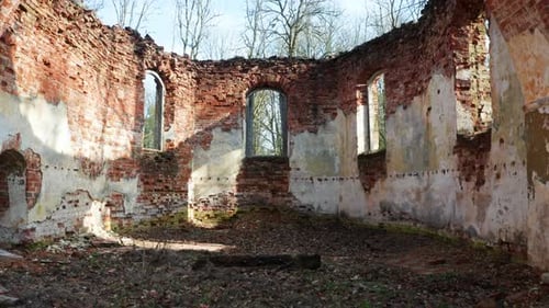 Abandoned church interior wall remains with arch shape wall and without roof