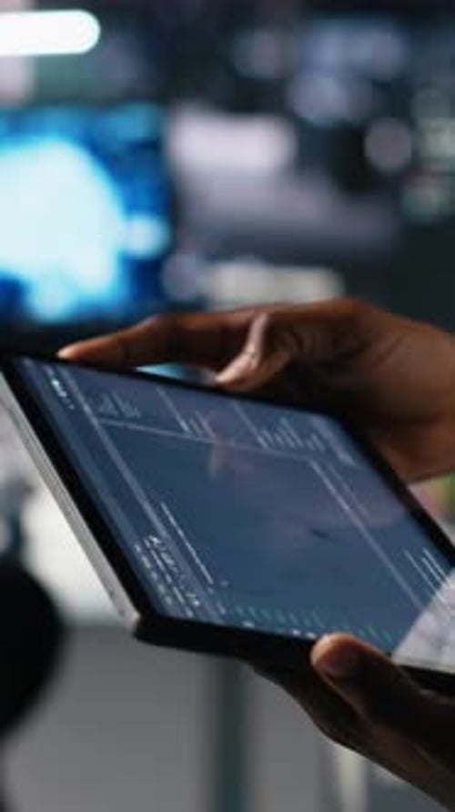 Vertical Video Close Up of Data Center Engineer Using Tablet to Review Code