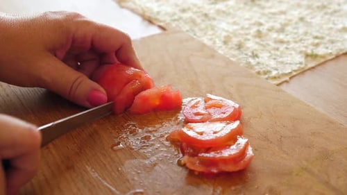 Close Up Cutting a Tomato on Cutting Board