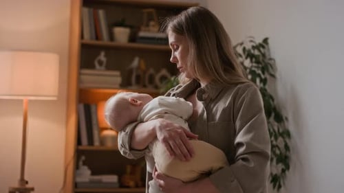 Mother Comforts Newborn Baby in Warm Home