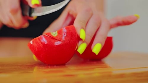Close Up of Woman Cutting Fresh Red Tomato with Knife on Wooden Board