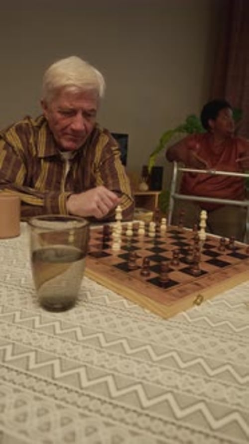Cheerful Elderly Man Enjoying Playing Chess in Nursing Home