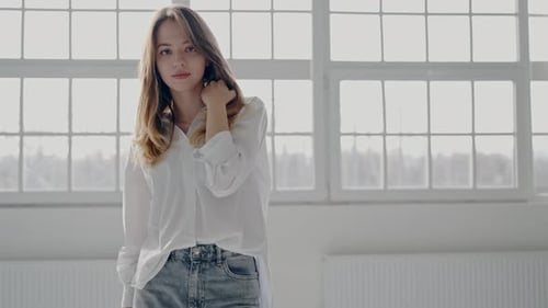 Young Woman in a Stylish Outfit Posing in a Bright Room