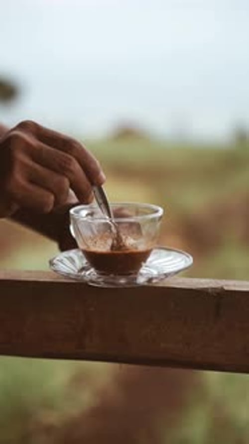 Adult Stirs a Hot Drink Outdoors