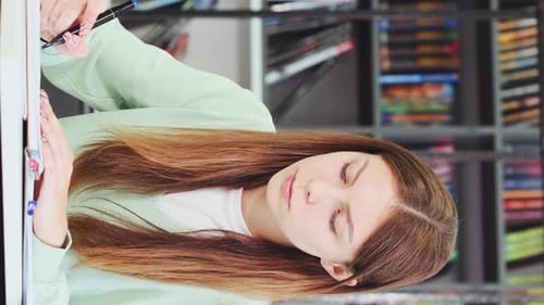 Vertical Screen: Caucasian female student studying in library