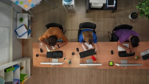 Vista superior da mesa do departamento de suporte do call center com computadores com os quais funcionários de equipe mista conversam