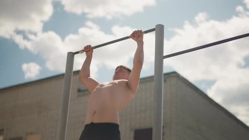 Athlete Challenges Heights Un passionné d'entraînement dévoué effectue des exercices du haut du corps au sommet d'une ville