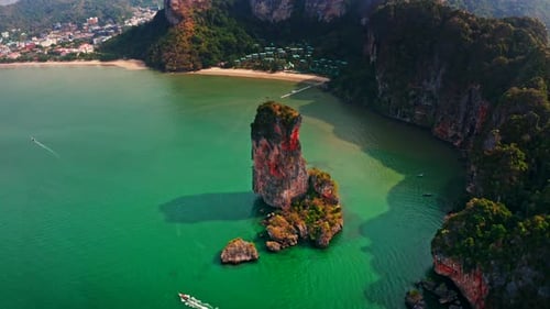 Close-up aerial shot of a towering limestone pillar in Krabi, Thailand. Vivid colors and warm tones