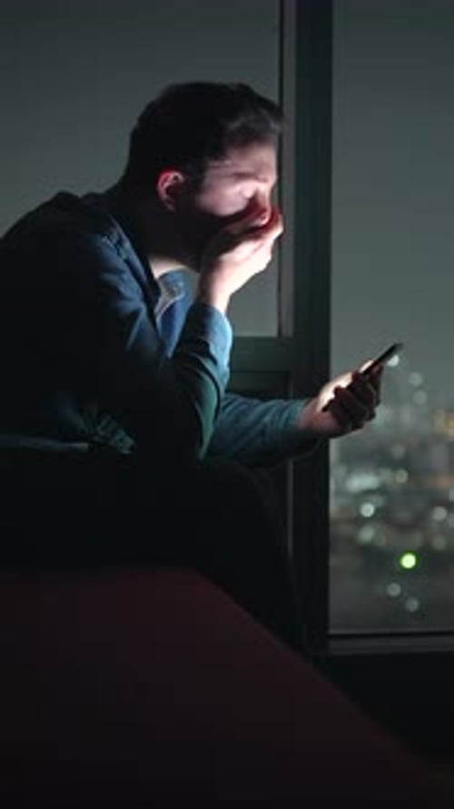 Evening Urban Individual Interacts with Screen Man in City Lights Gazes at His Illuminated Device
