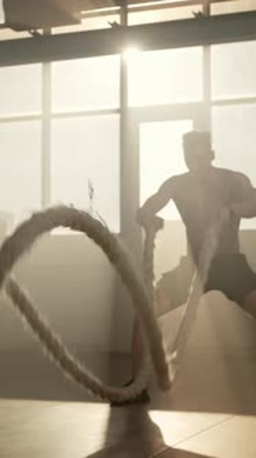 Strong Man Working Out With Ropes in Gym