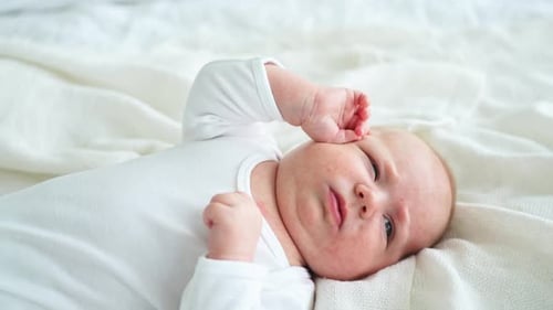 Infant Lying on White Blanket