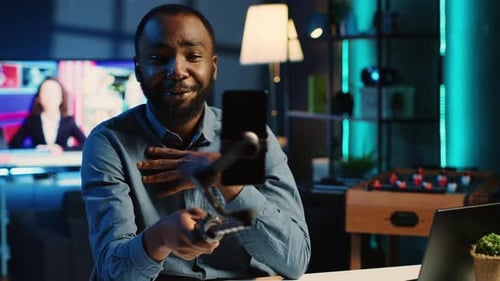 Man Vlogging with Phone and Tripod at Night