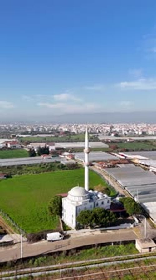 Vue aérienne verticale de la mosquée et des champs agricoles avec la ville en arrière-plan