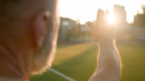 Close Up Old Man Grandfather Looking at Sun Rays Put Hand Out Sunset Warmth Fresh Air Training
